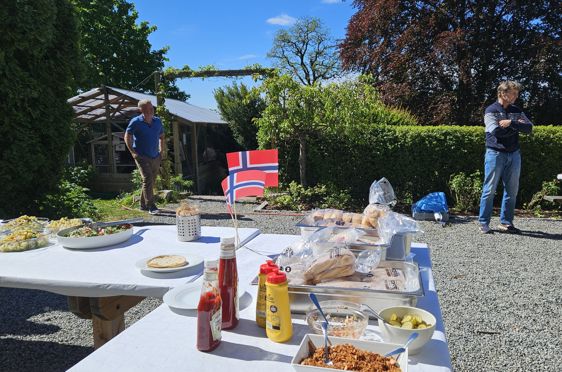 et par menn som står ved siden av et bord med mat på